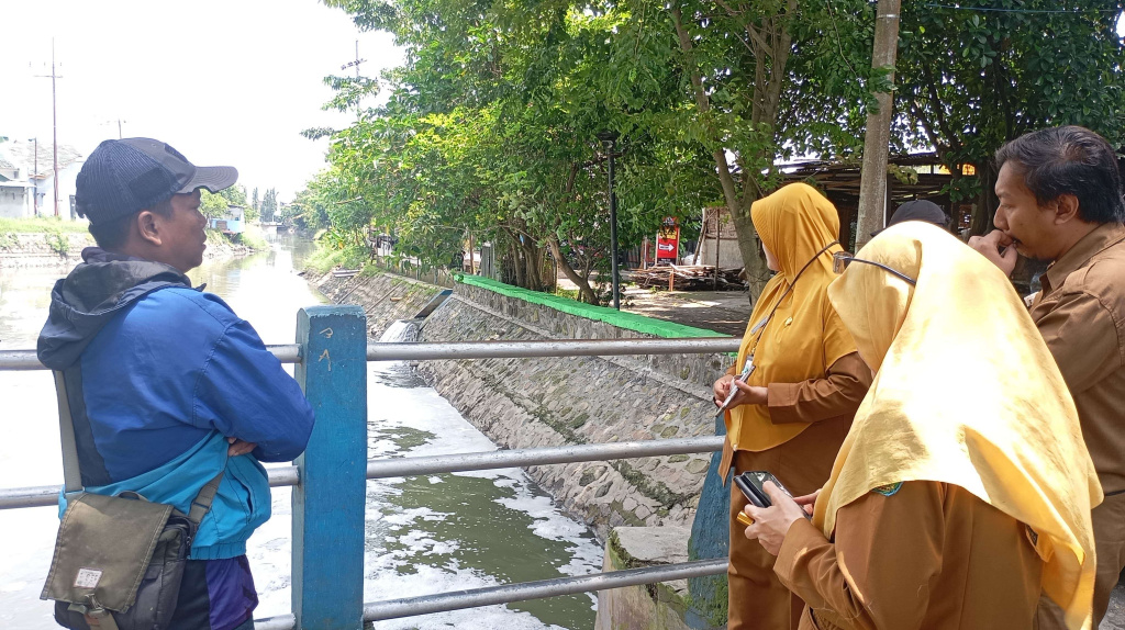 Petugas DLKH sedang meninjau lokasi sungai yang diduga tercemar limbah B3, Senin (19/01)2026). (Robi/ Tagarjatim.id)